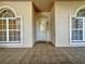 Front porch with tiled flooring, arched windows, and a light-colored door at 2289 Twickingham Ct, Clermont, FL 34711