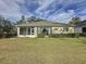 House back view, showcasing a large grassy backyard and screened-in porch at 2289 Twickingham Ct, Clermont, FL 34711