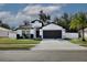 White house with dark gray garage door, landscaping, and a palm tree at 2320 Blue Meadows Ct, Apopka, FL 32703