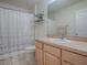 Clean bathroom with wood vanity, white sink, and patterned shower curtain at 2371 Wilson Way, The Villages, FL 32162