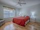 Bedroom with queen bed, red bedding, and hardwood floors at 2371 Wilson Way, The Villages, FL 32162