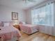 Guest bedroom with twin beds, light pink bedding, and hardwood floors at 2371 Wilson Way, The Villages, FL 32162