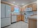 Kitchen with light wood cabinets, white appliances, and tile flooring at 2371 Wilson Way, The Villages, FL 32162