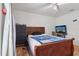 Bedroom with a wooden bed frame, ceiling fan, dresser, and a TV on a desk at 2385 Sw 159Th Ln, Ocala, FL 34473