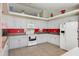 Spacious kitchen with white cabinetry, modern appliances, and a red accent wall at 2385 Sw 159Th Ln, Ocala, FL 34473