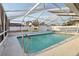 Sparkling pool under a screened enclosure, surrounded by a white fence and a small pool house at 2385 Sw 159Th Ln, Ocala, FL 34473