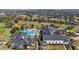Aerial view of community clubhouse, pool, and surrounding landscape featuring palm trees and manicured grounds at 2420 Prairie Dunes, Clermont, FL 34711