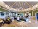 Spacious clubhouse interior with elegant seating, a fireplace, and ornate chandelier in a well-lit gathering space at 2420 Prairie Dunes, Clermont, FL 34711