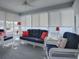 Relaxing sunroom with wicker furniture and red accents at 2549 Buttonwood Run, The Villages, FL 32162