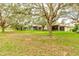 Serene backyard view with mature trees and a spacious lawn at 25921 San Rafael Ct, Howey In The Hills, FL 34737