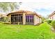 Home's exterior showcasing a large screened porch and well-manicured lawn at 25921 San Rafael Ct, Howey In The Hills, FL 34737