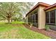 Side view of home with screened-in porch and landscaped area at 25921 San Rafael Ct, Howey In The Hills, FL 34737