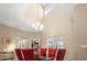 Bright dining area with a high ceiling, chandelier, and elegant glass dining table with red chairs at 26709 Augusta Springs Cir, Leesburg, FL 34748