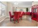 Bright dining room features a glass table and red chairs at 26709 Augusta Springs Cir, Leesburg, FL 34748