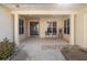 Inviting front porch with decorative columns, seating, and a blue front door with glass detailing at 26709 Augusta Springs Cir, Leesburg, FL 34748