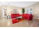 Living area with red couches, a coffee table, and tiled floors at 26709 Augusta Springs Cir, Leesburg, FL 34748