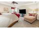 Main bedroom with king bed, chaise lounge, and large TV at 26709 Augusta Springs Cir, Leesburg, FL 34748