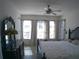 Bright bedroom with large windows, ceiling fan, and dark wood furniture at 314 Salt Marsh Ln, Groveland, FL 34736