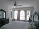 Bedroom with three windows offering natural light, ceiling fan, and elegant furnishings at 314 Salt Marsh Ln, Groveland, FL 34736