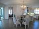 Dining area with elegant chandelier and kitchen access, ideal for Gathering meals and entertaining at 314 Salt Marsh Ln, Groveland, FL 34736