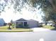 Single-story home with gray exterior, two-car garage, and landscaping at 314 Salt Marsh Ln, Groveland, FL 34736