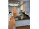 Well-lit kitchen features a breakfast bar, white cabinetry, stainless steel sink, and black countertops at 3450 Laurel Dr, Mount Dora, FL 32757