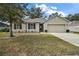 Exterior of single-story house with attached garage and landscaping at 36628 Grand Island Oaks Cir, Grand Island, FL 32735