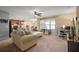 Living room with beige sofa, carpeted floor, and view of kitchen at 36628 Grand Island Oaks Cir, Grand Island, FL 32735