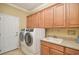 Bright laundry room featuring modern appliances and ample cabinetry at 370 Salt Marsh Ln, Groveland, FL 34736