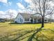 White farmhouse exterior with a large front yard and mature trees at 37146 Calhoun Rd, Eustis, FL 32736