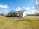 White farmhouse with large yard and mature trees at 37146 Calhoun Rd, Eustis, FL 32736