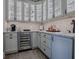 Modern kitchen corner with wine cooler and white cabinets at 3735 Conservation Trl, The Villages, FL 32163