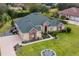 An aerial view showcasing a beautiful house with a green roof and stone exterior at 39248 Tacoma Dr, Lady Lake, FL 32159