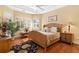 Bright bedroom with wood floors, wicker bed frame, and plantation shutters at 39248 Tacoma Dr, Lady Lake, FL 32159