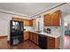 Black appliances and wood cabinets in this galley kitchen at 39645 Turek Ln, Umatilla, FL 32784