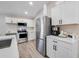 Modern kitchen with white cabinets, stainless steel appliances, and breakfast bar at 460 Brook Ridge Cir, Minneola, FL 34715