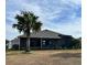 Home's backyard showcasing screened patio and palm trees at 5078 Lawler Loop, The Villages, FL 32163