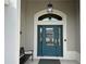 Teal front door with glass panels and a black metal bench at 5078 Lawler Loop, The Villages, FL 32163