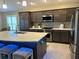 Modern kitchen with island, stainless steel appliances, and white countertops at 5078 Lawler Loop, The Villages, FL 32163