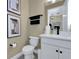 Stylish half-bathroom with white vanity, dark accents, and modern decor at 5221 Blanket Flower St, Apopka, FL 32712