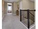 Upstairs hallway featuring carpet flooring, and an ornamental iron railing staircase at 5221 Blanket Flower St, Apopka, FL 32712