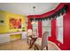 Charming breakfast nook with glass table and red accent wall at 526 Kingston Way, The Villages, FL 32162