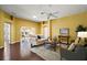 Bright living room features hardwood floors, comfortable seating, and a view into the dining area at 526 Kingston Way, The Villages, FL 32162