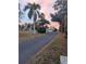 Home with palm trees and sunset in background, long driveway leads to the house at 5526 Parkdale Dr, Orlando, FL 32839