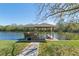 Covered dock with seating and boat lift at 6026 Landings Blvd, Lady Lake, FL 32159