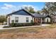 White and dark trim home with a walkway leading to the front door at 6832 Maryland Ave, Groveland, FL 34736