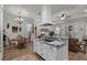 Modern kitchen boasts an island with cooktop, white cabinets, and views to the living room at 6832 Maryland Ave, Groveland, FL 34736