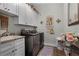 Bright laundry room with white cabinets, granite countertop, and modern washer/dryer at 6832 Maryland Ave, Groveland, FL 34736