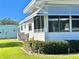 Side view of a well-maintained single-story home with an enclosed porch and green lawn at 106 Gardenia Way, Leesburg, FL 34748