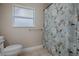 Simple bathroom with shower, toilet, and a window for natural light at 1415 Park Ave, Tavares, FL 32778